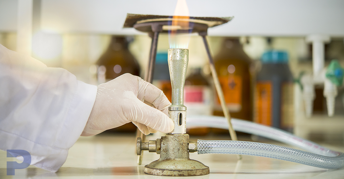 A hand holding a bunsen burner